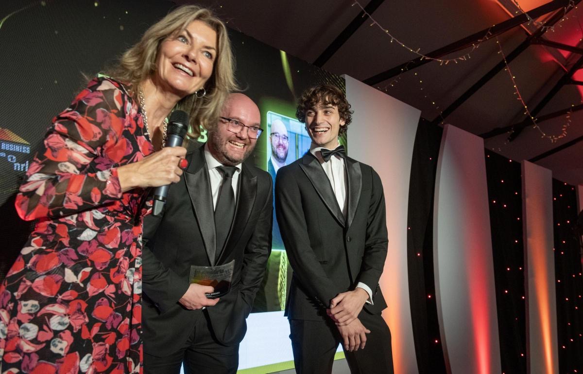 Two award winners being interviewed on stage at a business awards evening